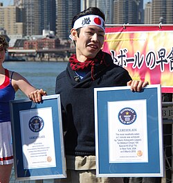 Japanese competitive eater Takeru Kobayashi with two Guinness World Record certificates