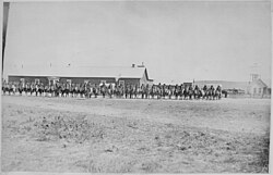 Sioux Indian police lined up on horseback in front of Pine Ridge Agency buildings, Dakota Territory, August 9, 1882