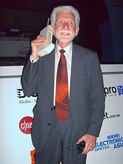 Martin Cooper of Motorola, shown here in a 2007 reenactment, made the first publicized handheld mobile phone call on a prototype DynaTAC model on 3 April 1973.