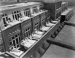 Tuberculosis patients lie in beds on the porch of a building at the Jewish Consumptive Relief Society (J.C.R.S.) sanatorium