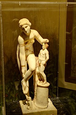 The so-called "Venus in a bikini", depicts her Greek counterpart Aphrodite as she is about to untie her sandal, with a small Eros squatting beneath her left arm, 1st-century AD.[b]