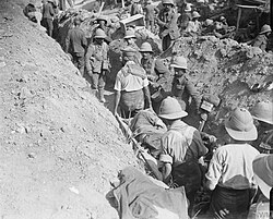 RAMC stretcher bearers carrying a wounded soldier through a trench at Cape Helles during the Gallipoli campaign, 7 August 1915