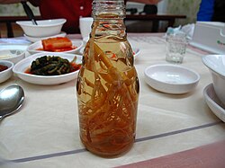 Ginseng roots in a bottle of liquid