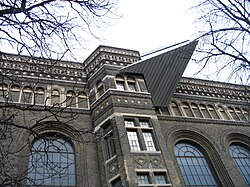 Arched and bay windows along the building's western façade with a very small section of the Crystal jutting out on the top