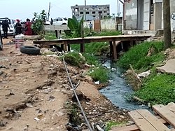 This area is contaminated with stagnant water and refuse, making the environment unhygienic.