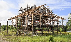 The wooden frame of a house under construction, with the floor raised off the ground