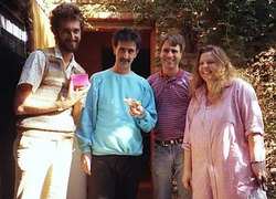 Left to right: Simon Prentis (Zappa's "Semantic Scrutinizer"), Zappa, Zappa's production assistant Gerry Fialka, and Zappa's second wife Gail outside Zappa's home recording studio Utility Muffin Research Kitchen in 1986. Prentis holds a preview cassette of the album Jazz From Hell that Fialka had just delivered for Zappa's approval.[143]