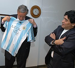 Maradona (right) presenting a signed jersey to the former President of Argentina Néstor Kirchner in December 2007