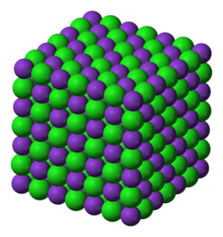 The crystal lattice structure of potassium chloride (KCl), a salt which is formed due to the attraction of K+ cations and Cl− anions. The overall charge of the ionic compound is zero.