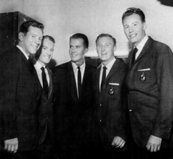 The band with Dick Clark. Left to right: Bob Bogle, Howie Johnson, Dick Clark, Don Wilson and Nokie Edwards.