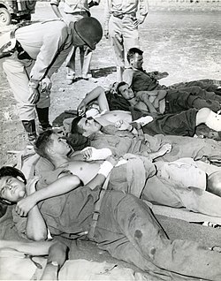 Patton talks to wounded soldiers preparing for evacuation.