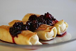 Blinchiki filled with cheese and topped with blackberries