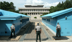 South Korean soldiers at the Joint Security Area (JSA) between the blue buildings, with North Korea in the background