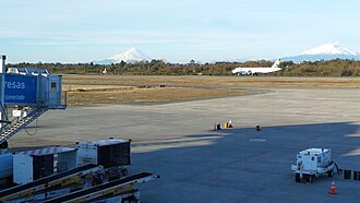 El Tepual International Airport with Calbuco and Osorno volcanoes in the background. A Sky Airline Airbus A-320 jet is also visible.