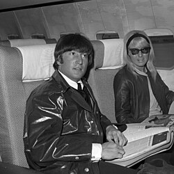 John and Cynthia Lennon sitting in an airplane on a stopover in Los Angeles in 1964