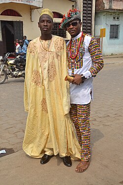 Cameroonian fashion is varied and often mixes modern and traditional elements. Note the wearing of sun glasses, monk shoes, sandals, and a Smartwatch.