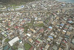 An aerial view of part of Roseau, revealing widespread damage to roofs. Flash floods clogged roads with debris—vegetative and structural—and mud.