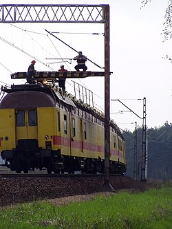 Lineworkers on a maintenance of way vehicle repairing overhead lines (Poland)