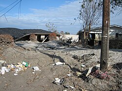 Severely damaged homes in piles of sand near the upper London Avenue Canal breach