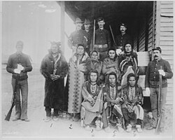 Chief Plenty Coups and eight Crow prisoners under guard at Crow agency, Montana, 1887