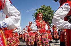 Women wearing red traditional Portuguese costumes with embroidered aprons and gold jewelry at the Romaria de Nossa Senhora da Agonia.