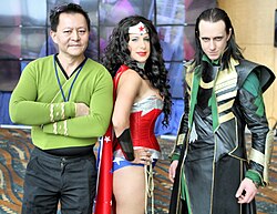 Three cosplayers at the Comic Con in Long Beach 2014, representing James T. Kirk (Star Trek), the superheroine Wonder Woman (DC Universe), and supervillain Loki (Marvel Universe)