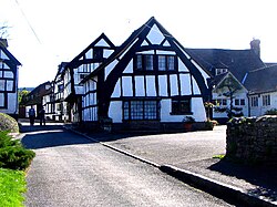A "true" or "full" cruck half-timbered building in Weobley, Herefordshire, England: The cruck blades are the tall, curved timbers which extend from near the ground to the ridge.