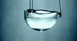 Liquid helium retains kinetic energy and does not freeze regardless of temperature at standard atmospheric pressure due to zero-point energy. When cooled below its Lambda point, it exhibits properties of superfluidity.