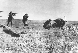 Members of the Einsatzgruppen prepares to shoot a Jewish mother holding her child, Ivangorod, Ukraine