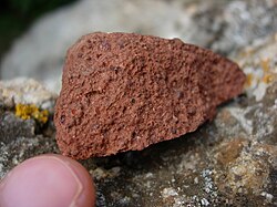 Bauxite, a major aluminium ore. The red-brown color is due to the presence of iron oxide minerals.
