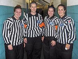 Officials working under a four-official system. Orange armbands are worn by the referees to distinguish them from the lineswomen.