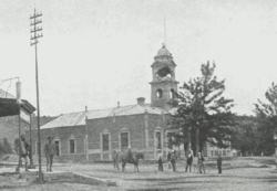 The town hall during the siege in 1900, with Boer artillery damage to the bell tower