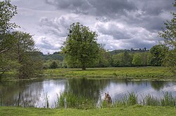 wooden gate with field and low hill beyond