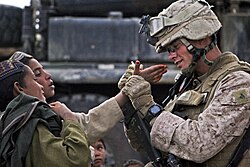 A US marine interacting with Afghan children in Helmand Province
