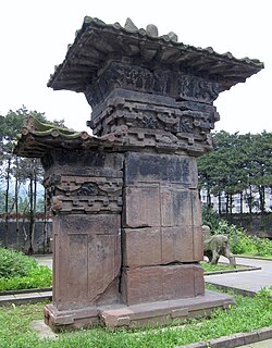 A stone-carved pillar-gate, or que (闕), 6 m (20 ft) in total height, located at the tomb of Gao Yi in Ya'an, Sichuan province, Eastern Han dynasty (25–220 AD);[39] notice the stone-carved decorations of roof tile eaves, despite the fact that Han dynasty stone que (part of the walled structures around tomb entrances) lacked wooden or ceramic components (but often imitated wooden buildings with ceramic roof tiles).[40]