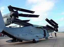 A V-22 with its wing rotated 90 degrees so it runs the length of the fuselage.