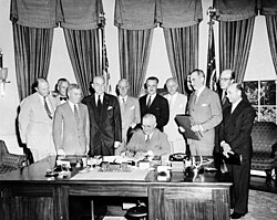 President Truman signs the North Atlantic Treaty with guests in the Oval Office