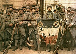 French Poilus posing with their war-torn flag in 1917, during World War I