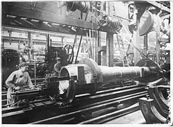A female worker turning a barrel for a 280-mm howitzer Mle 1914 at the Harfleur plant, 1916