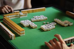 A group of people playing a game of mahjong