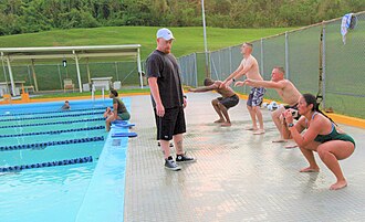 Swimmers perform squats as warm-up exercise prior to entering the pool in a U.S. military base, 2011.