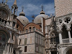 A wider view from the picture above, showing (on San Marco at left) the domes, fancy stone veneers, and at top left, two stone grilles.