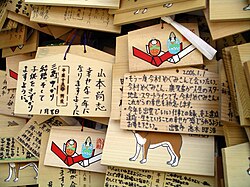 A selection of wooden ema hanging up at a Shinto shrine