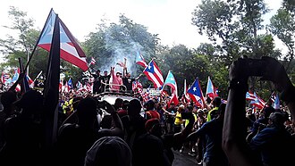 Protesters celebrating the resignation of Ricardo Rosselló in San Juan, the day after the announcement. Residente, Bad Bunny and Ricky Martin (center, L–R) were among many public figures that demanded Rosselló's resignation.