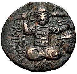 Turk seated facing with legs crossed, holding sword and crowned severed head, with legend to left "Nur al-Din Atabeg" (نور الدين اتا / بك), probably Nur al-Din Arslan Shah I. Coinage of Husam al-Din Yuluq Arslan, dated AH 596 (1199–1200 CE).[79][80]