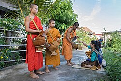 Buddhist monks collect alms in Si Phan Don, Laos. Giving is a key virtue in Buddhism.