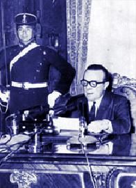 A military adjutant watches over interim President Guido, an unwitting metaphor as Army factions wrestled for control of his puppet regime.