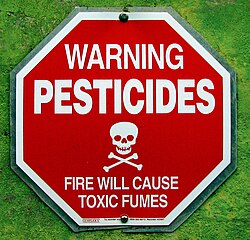 A sign warning about potential pesticide exposure