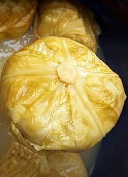 Whole sour cabbage in a barrel with brine