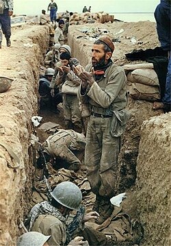 Iranian soldiers praying inside a trench during the Iran–Iraq War